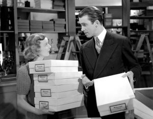 Main leads of the movie, carrying boxes and looking at each other